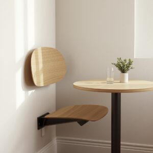 Wall-mounted foldable dining chair unfolded beside a small bistro table in a compact dining nook